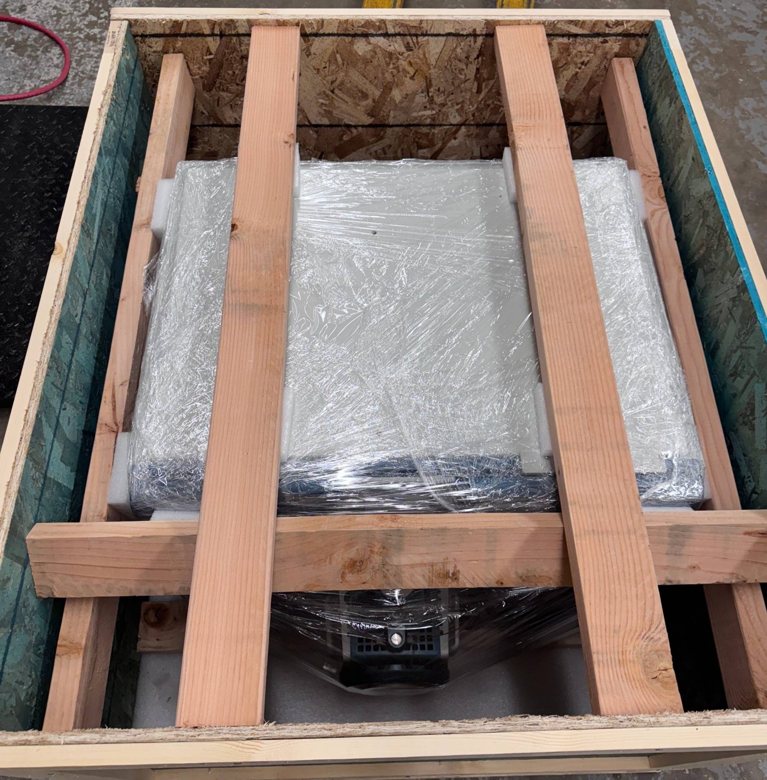 SCIEX QTRAP 6500+ inside a lumber crate, blocked and braced with 2x4s secured through the crate walls