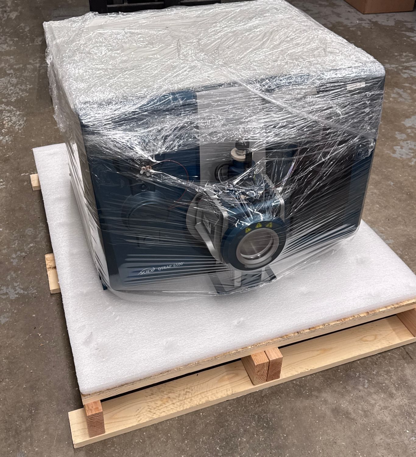SCIEX QTRAP 6500+ prepped, shrink-wrapped, and sitting on an anti-vibration foam pad on the crate base